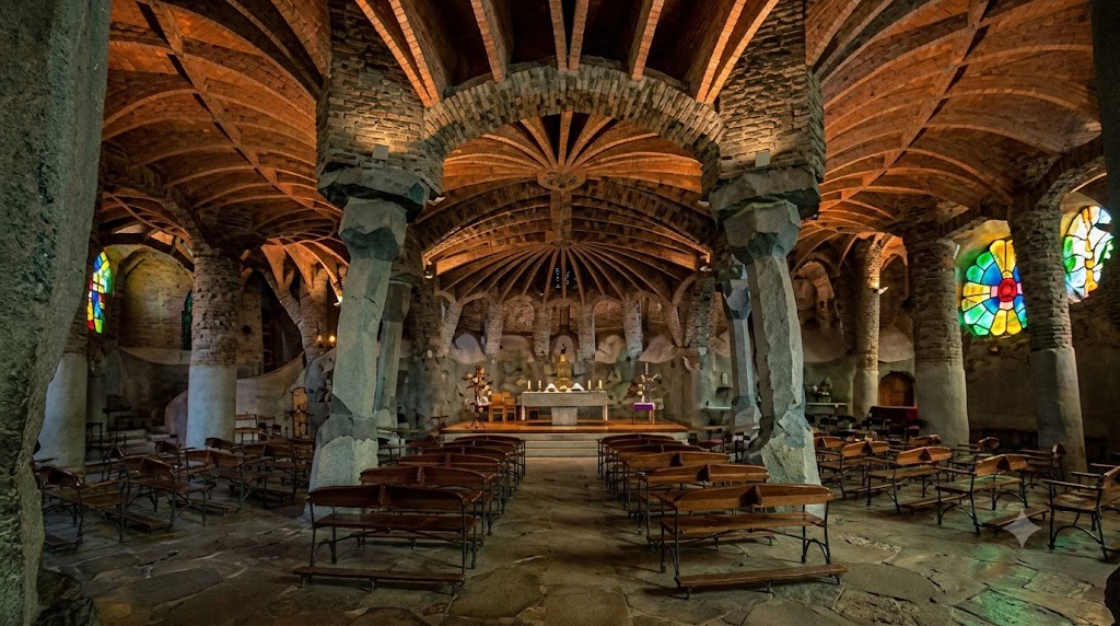 Interior of the Gaudí Crypt in Colònia Güell showing angled columns and stained glass